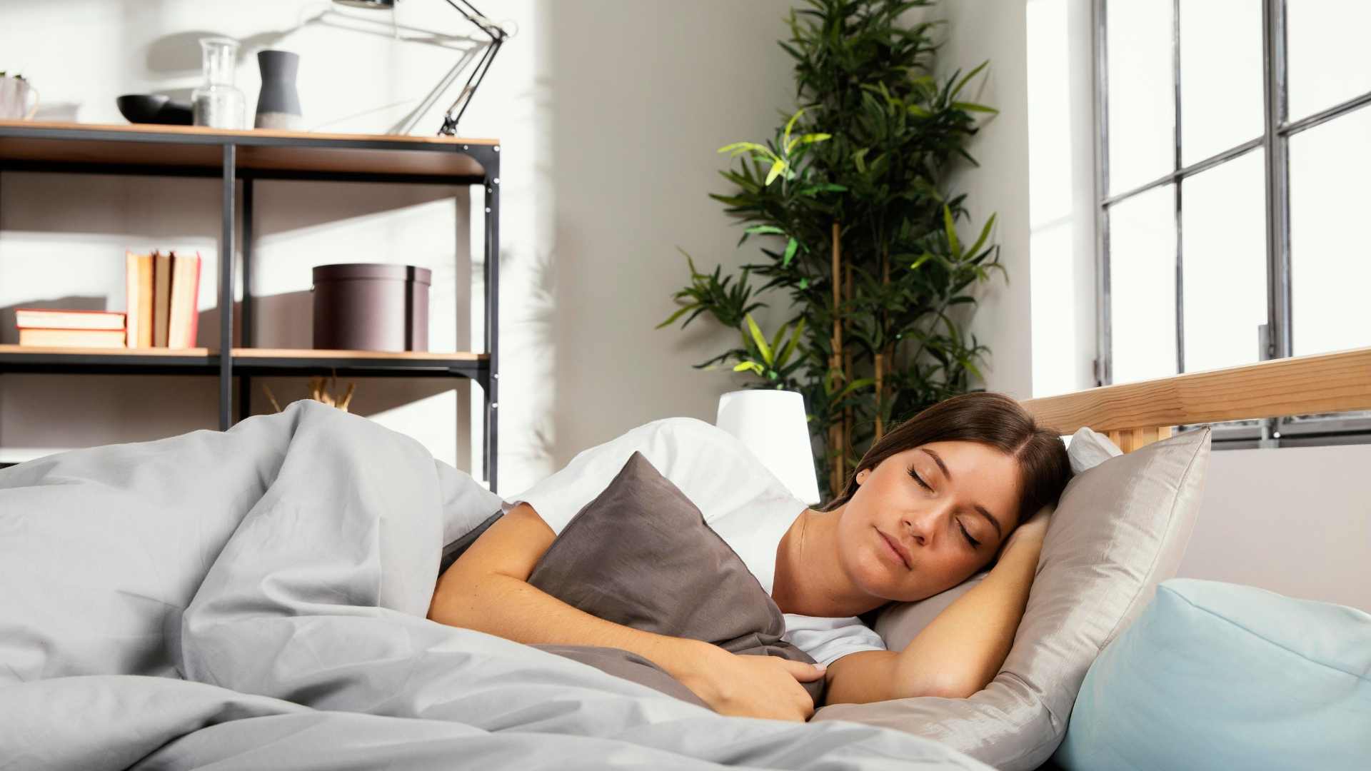 Seseorang tidur nyenyak di atas tempat tidur sebagai cara memulihkan energi setelah mengalami tanda tubuh butuh istirahat.